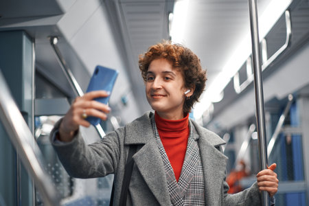 young woman taking a selfie while riding the subway.の写真素材