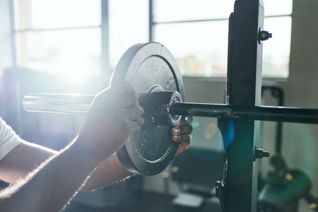 bodybuilder hanging a sports pancake on a barbell. close-up.