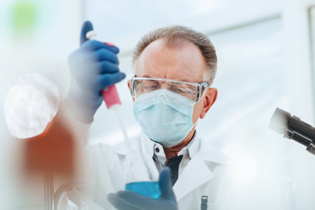 close up. researcher using an automatic dispenser in a medical laboratory.の写真素材