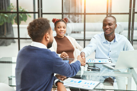 financial partners shaking hands during an office meeting .の写真素材