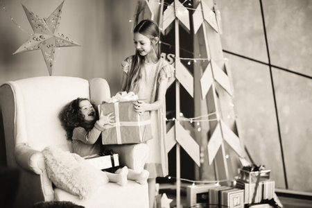 two happy little sisters with Christmas presents. black and white photoの写真素材