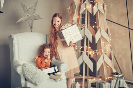 two little girls with Christmas presents on Christmas eveの写真素材