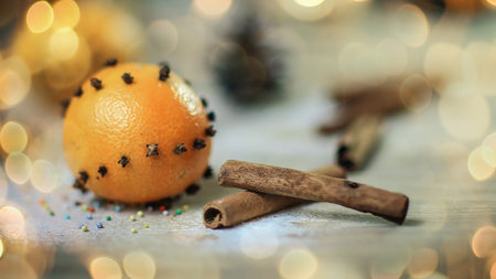 Christmas table. background image of cinnamon sticks, oranges and cookies on wooden background. photo with copy space. beautiful bokeh effect from a garland.の写真素材