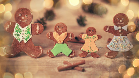 cheerful gingerbread men gingerbread house on the table. beautiful bokeh effect from a garland.の写真素材