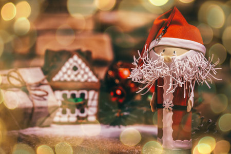 gift for Christmas ,gingerbread house, a toy Santa Claus. beautiful bokeh effect from a garland.の写真素材