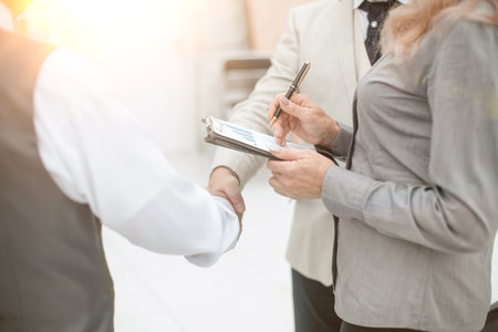 close up. financial partners shaking hands in the office. handshake at sunset with a sun glareの写真素材
