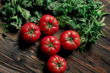 juicy tomatoes and parsley on a wooden countertop.の写真素材
