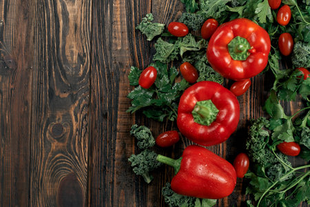 tomatoes and red bell peppers on a wooden board.の写真素材