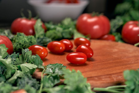 background image of tomatoes on a wooden kitchen board.の写真素材