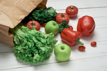 bag of fresh vegetables on a light wooden background .の写真素材