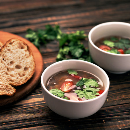 slice of bread and two plates of soup on a wooden board.の写真素材