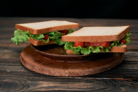two tomato sandwiches on a wooden board.の写真素材
