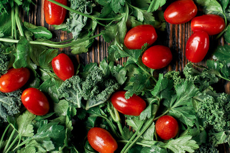fresh tomatoes and sprigs of parsley on a wooden table.の写真素材