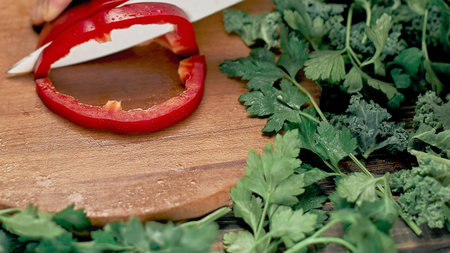 man slicing paprika on the kitchen table.の写真素材