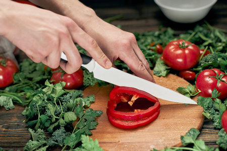 man slicing paprika on the kitchen table.の写真素材
