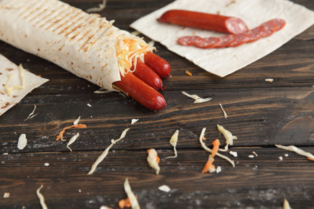 smoked sausage in pita bread on a wooden tableの写真素材