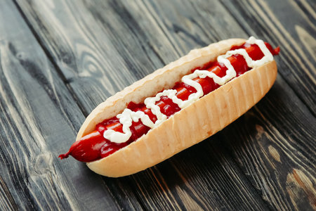 hot dog with smoked sausage and mayonnaise on wooden backgroundの写真素材