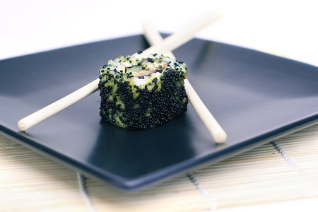 close-up of sushi and chopsticks on a black plateの写真素材