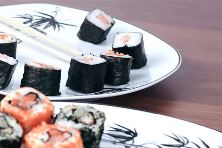 sushi rolls and chopsticks on a wooden tableの写真素材