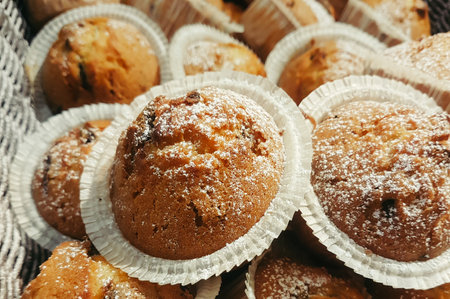 delicious chocolate muffins with powdered sugar in a basketの写真素材