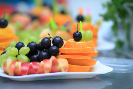close up.apples, oranges and grapes on a plateの写真素材