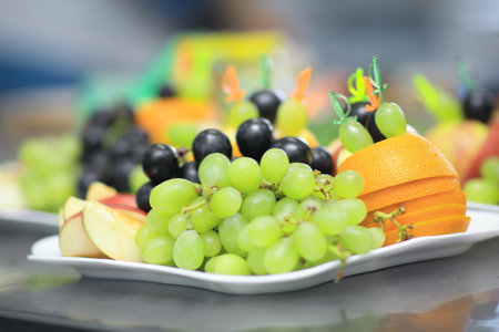 close up.plate with grapes and oranges on blurred backgroundの写真素材