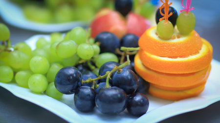 close up.plate with grapes and oranges on blurred backgroundの写真素材