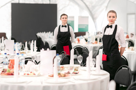 young waitress standing in the Banquet hall of the restaurantの写真素材