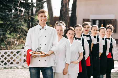 restaurant staff standing on the lawn near the restaurantの写真素材