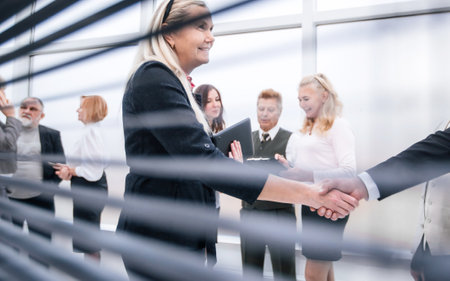 through-blinds. business colleagues meeting each other with a handshake.の写真素材