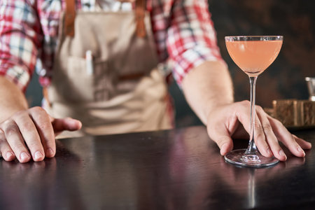 male bartender serves a ready-made alcoholic cocktail.の写真素材