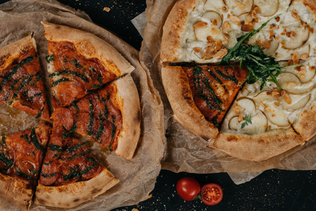 Pepperoni pizza and pizza with pear gorgonzola and almond served on parchment paperの写真素材