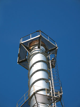 The factory chimney photographed on a background of the blue skyの写真素材