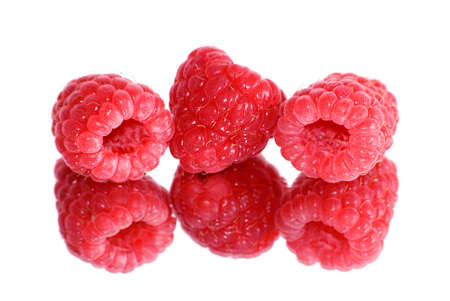 Three berries of a raspberry are reflected in a mirrorの写真素材