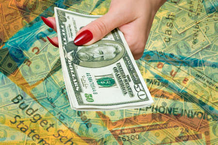 The female hand holds some denominations on 50 dollarsの写真素材