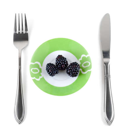 Three berries of a blackberries lays on a plateの写真素材
