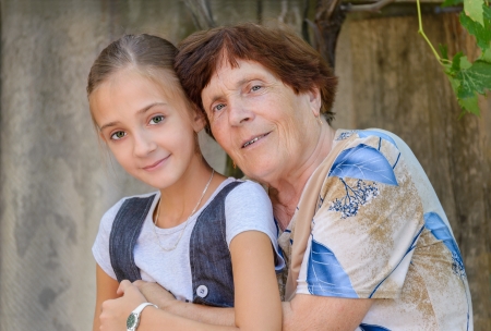 Grandmother and granddaughter is sitting embracing