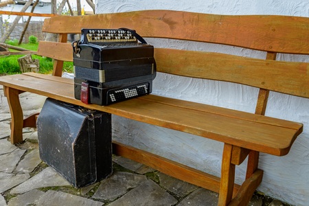 Old button accordion is on the benchの写真素材