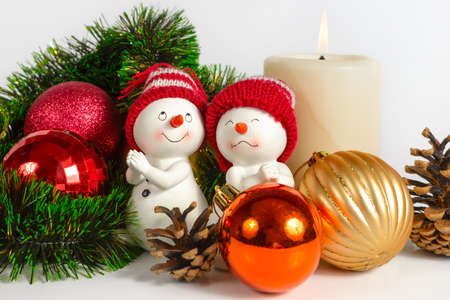 Christmas still life with snowman toy, balls, cones and burning candleの写真素材
