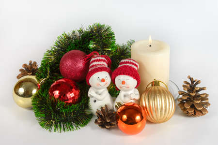 Christmas still life with snowman toy, balls, cones and burning candleの写真素材