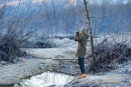 The photographer takes a picture of winter forestの写真素材