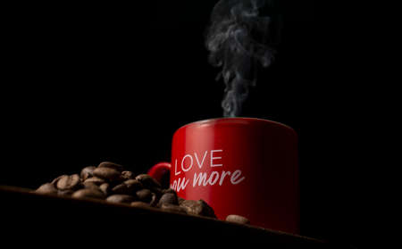 Red coffee cup on wooden table, coffee grains, black backgroundの写真素材