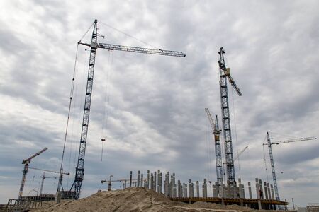 Many tower cranes work on a huge construction site of the housing estate being built