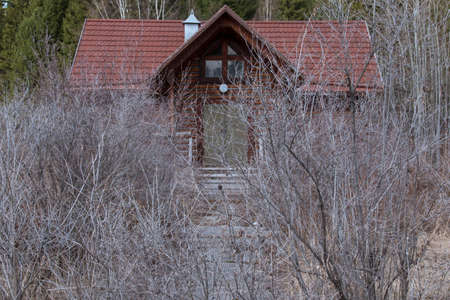 Behind the wall of shrubs you can see the path leading to the old wooden buildingのeditorial素材