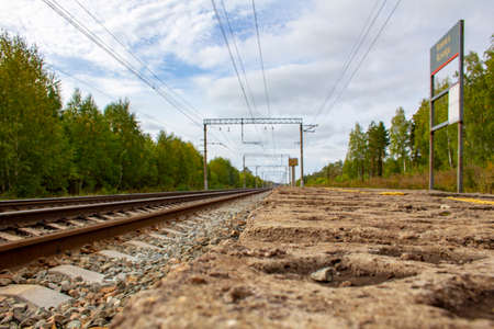 Old concrete platform of a small railway station. Small covered stop