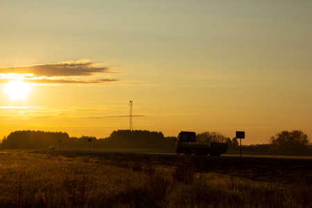 Morning highway. The trailer drives along the highway towards dawn. Dawn painted the landscape yellowの写真素材