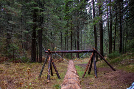 A sports equipment for walking on a log, built in the forest from wood and chains. Competition Obstacle Courseの写真素材