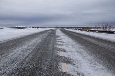 Winter track in the North. Two-lane track with bumpers, fences, snow and ice.