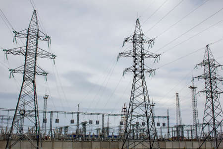 Power line masts grow on the forest. Industrial energy landscape