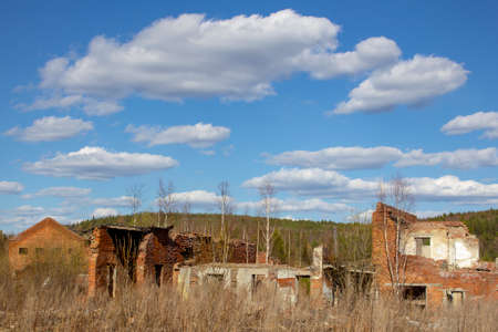 Ruins of an industrial building and a brick tower in the Urals. Tall brick tower and ruins. Majestic...